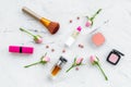 Decorative cosmetics layout. Pink tones of lipstick, bulk, eyeshadow, perfume, brushes among rose flowers on white Royalty Free Stock Photo