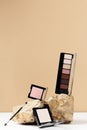 Decorative cosmetics for make-up kit. Open case of eyeshadow palette, powder, blush and maquillage brush on stone Royalty Free Stock Photo