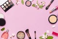 Decorative cosmetics mascara powder lipstick eyeshadow blush balls makeup brush perfume blooming spring branches on pink Royalty Free Stock Photo
