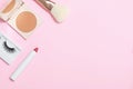 Decorative cosmetics on a pink background. Compact Powder Makeup Brush False Eyelashes Lipstick. Copy space flat lay top view Royalty Free Stock Photo