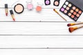 Decorative cosmetics set with eyeshadow, rouge, lipstick, brushes on white desk background top view copy space