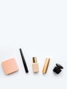 Decorative cosmetics on a white background: powder, eyeliner, foundation, lipstick