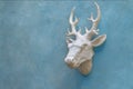 Decorative deer head sculpture on cement blue wall, template, space for text
