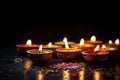 decorative diwali oil lamps glowing on dark background generative AI Royalty Free Stock Photo