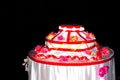 Decorative dummy cake with flowers and red ribbons on black background Royalty Free Stock Photo