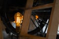 Decorative edison style light bulb against wooden stairs and bicycle wheel. bokeh background and copy space. lightning decoration. Royalty Free Stock Photo