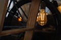 Decorative edison style light bulb against wooden stairs and bicycle wheel. bokeh background and copy space. lightning decoration Royalty Free Stock Photo