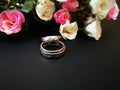 Closeup with wedding rings and beautiful roses flower background. Royalty Free Stock Photo