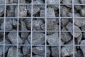 Decorative fence of bulk stone in the grid. Textured background of a stone wall with iron netting.Gabion filled with limestone Royalty Free Stock Photo