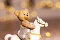 Decorative figurines of a Christmas theme. Figurine of a little teddy bear on a rocking horse. Christmas tree decoration. Festive