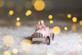 Decorative figurines of a Christmas theme. Santa statuette rides on a toy car with a trailer for gifts. Festive decor, warm bokeh Royalty Free Stock Photo