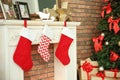 Decorative fireplace with stockings near beautiful tree and gifts indoors Royalty Free Stock Photo