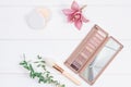 Decorative flat lay composition with makeup products, cosmetics and flowers. Flat lay, top view on wooden background.