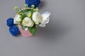 Decorative flowers in a bucket and blue balls on a gray background