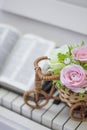 Decorative flowers roses in a wicker bicycle on the piano and the Bible. Topiary. Wedding decor, decoration.