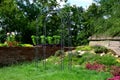 Decorative garden behind the wall, with a wooden table and decorative trellis for climbing plants or for garden wedding ceremonies