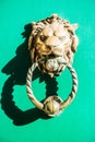 Decorative gilded lion head door knocker on green door Bruges