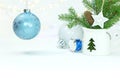 Glass christmas balls, green fir tree branch and drum toy against white background with blurred glowing light garlands Royalty Free Stock Photo