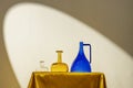 Decorative glass jars of different colors on a golden fabric structure under the light of a spotlight Royalty Free Stock Photo