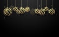 Decorative golden Christmas balls hanging on black background