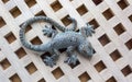 Decorative green lizard made of stone on wooden boards