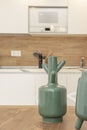 decorative green vases on wooden table and kitchenette in the background