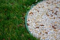 Decorative ground in the garden with artificial grass, gravel and explsed aggregate finish Royalty Free Stock Photo