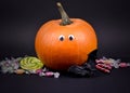 Spooky halloween pumpkin with eyes, candies and bat stock images Royalty Free Stock Photo