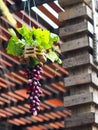 Decorative hanging hand crafted vase made of synthetic flowers and green plant leaves Royalty Free Stock Photo