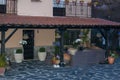 Decorative hanging planter with wicker pot of blue flowers on front porch with slate floor