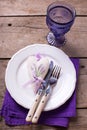 Decorative heart, knife and fork on white plate on vintage wood
