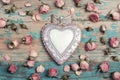 Decorative heart with small rose flowers on the turquoise old wooden background with copy space. Royalty Free Stock Photo