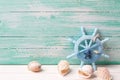 Decorative helm and marine items on turquoise wooden background.