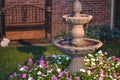 Decorative home water fountain in a bed of flowers