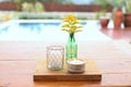 decorative image with flower ande candles in the external area of a house with a swimming pool