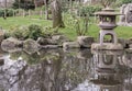 Decorative japanese stone lantern on Summer zen lake pond water Royalty Free Stock Photo