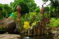 Decorative jungle bamboo waterfall with foliage and statues
