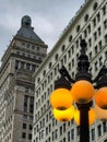 Decorative Lamp Post With Yellow Globe Lights By Buildings