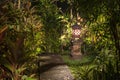 Decorative lamp on the stone pillar next to the path in the tropical garden at night . Island Bali, Indonesia . Nature concept Royalty Free Stock Photo