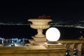 Decorative lantern and flowerpot with geraniums stand on the railing of the stairs leading from Bahai Garden upper entrance, at ni