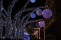 Decorative LED ball shaped lamps illuminate street at night. Outdoor winter holidays decoration. Beautiful purple lamps, street