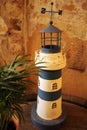 Decorative lighthouse standing on table with potted plant