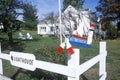 Decorative lighthouse weathervane on white picket fence by a white house, MI Royalty Free Stock Photo