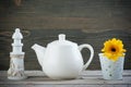 Decorative lighthouse, white teapot and yellow flower