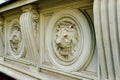 decorative lion head stone relief closeup. ornate window sill and ledge and stucco wall detail