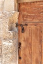 Decorative massive wooden door with a metal bolt and a metal padlock to a residential building in the Arab Christian village