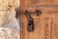 Decorative massive wooden door with a metal bolt and a metal padlock to a residential building in the Arab Christian village