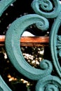 Decorative metal bench or fence featuring an intricate pattern of swirls, circles, and other shapes