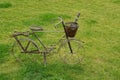 Decorative metal bicycle with basket and scoop standing on the lawn