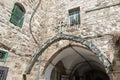 Decorative metal cross mounted on a metal arch in a quiet street in the Old City in Jerusalem, Israel Royalty Free Stock Photo